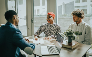 A couple reviewing mortgage documents with a lender at a table