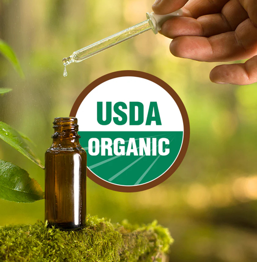 A botanical essential-oil bottle held above moss