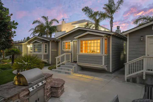 Modern single-story Pismo Beach vacation home with wooden deck and patio at dusk