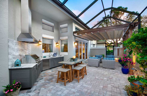 Luxury outdoor kitchen with bar seating and tropical landscaping