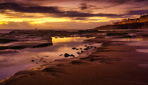 Golden and purple sunset light reflected in rocky coastal tide pools
