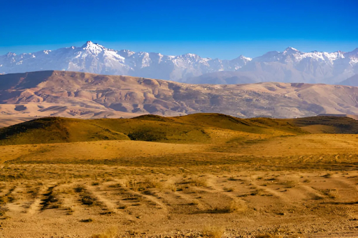 Agafay Desert rocky hills and Atlas Mountains near Marrakech Morocco