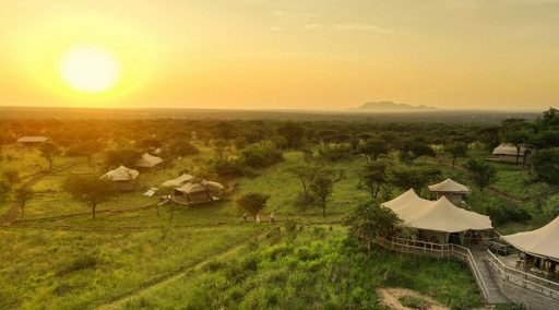 Aerial view of a luxury tented camp in the Serengeti at sunset