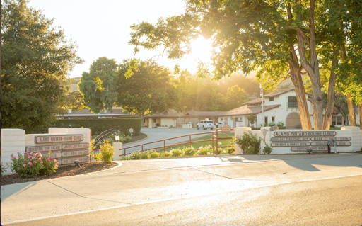 Entrance to Alamo Pintado Elementary School in Santa Ynez with stone signs, paved driveway, and buildings surrounded by trees