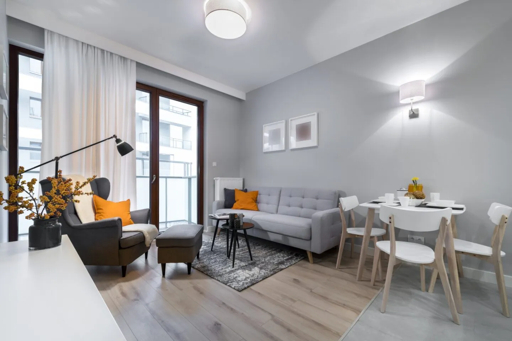 Professionally staged modern living and dining room with neutral decor and large windows