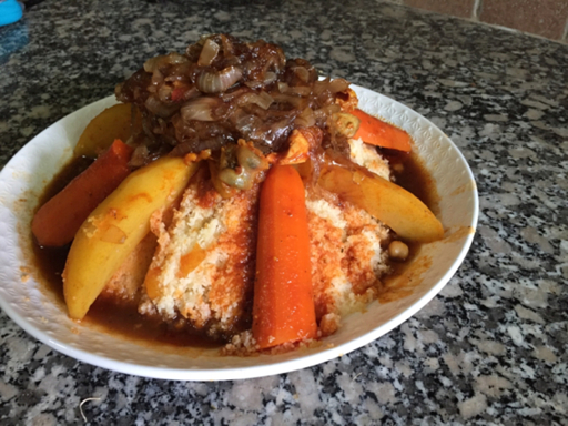 Moroccan couscous with meat and vegetables in a white bowl