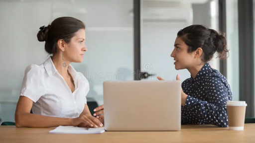 HR professionals collaborating in a business meeting with documents and laptop