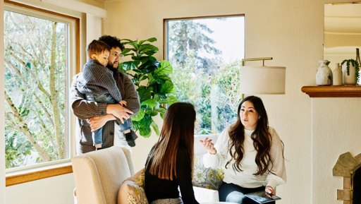 Real estate professional meeting with clients to review home-buying or selling options