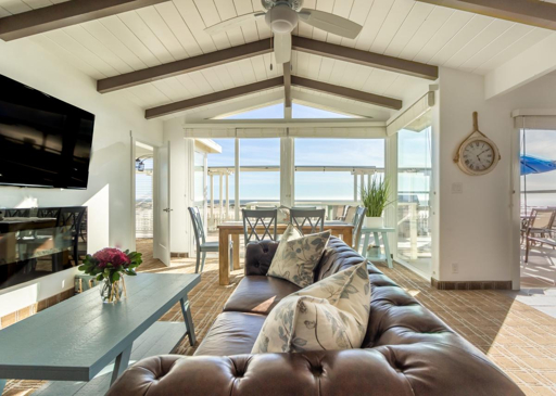 Modern beach house living room with ocean-view balcony and large windows in Pismo Beach vacation rental
