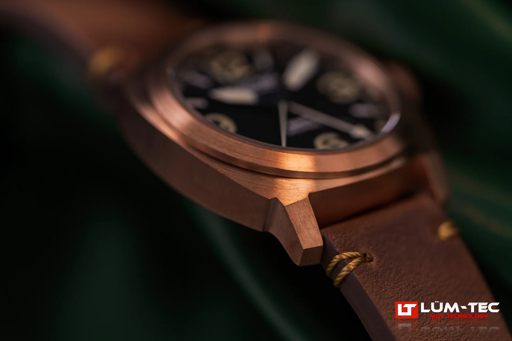 Lüm-Tec M94 Bronze Date watch with bronze case, black dial, and brown leather strap