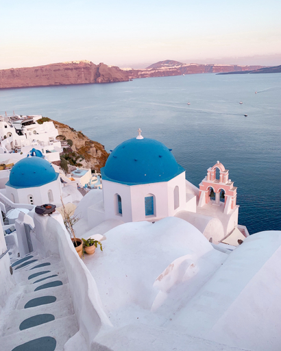 Les dômes bleus et la mer de Santorin au coucher du soleil