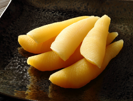 Bright yellow herring roe kazunoko on a dark plate