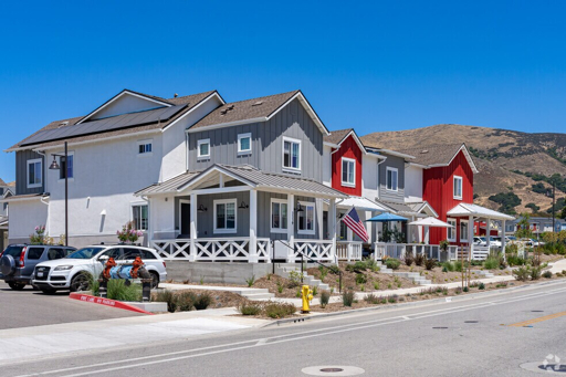 Sunny residential street in Orcutt with modern two-story homes and hills in the background