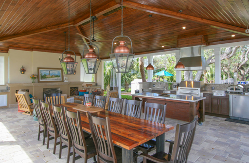 Spacious outdoor kitchen with dining table and stainless appliances