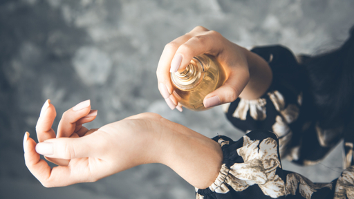A woman applying perfume to her wrist